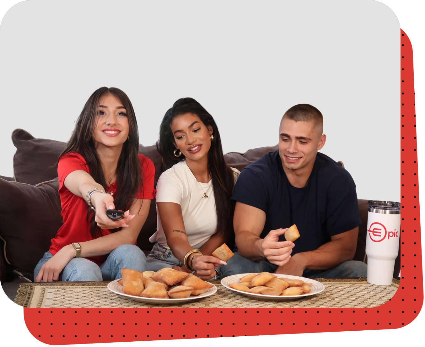 Three people sitting on a couch eating donuts